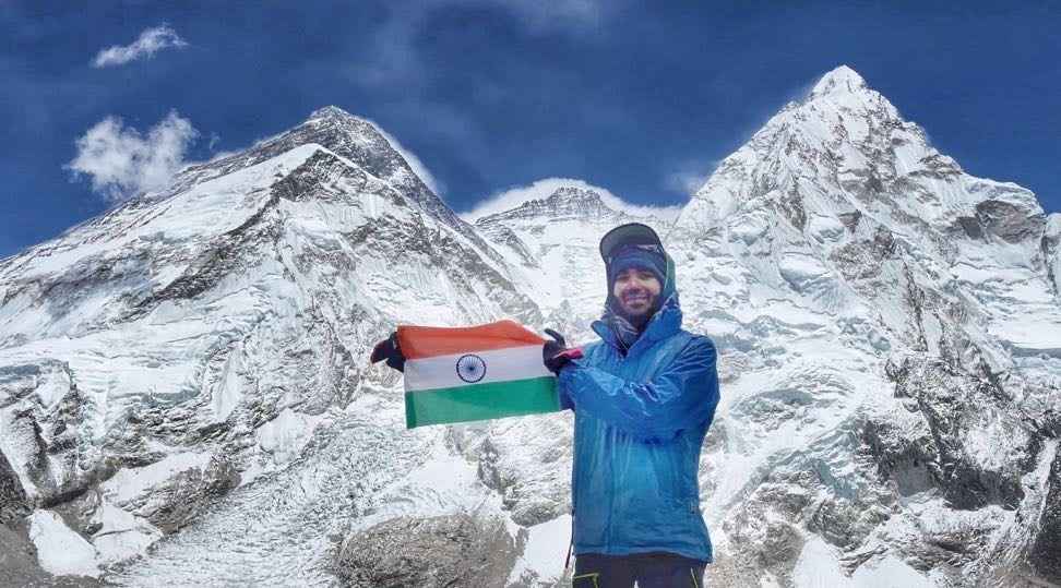 Happy man climber in bright red down jacket reaches the summit of mount  Everest, Nepal. Stock Photo | Adobe Stock